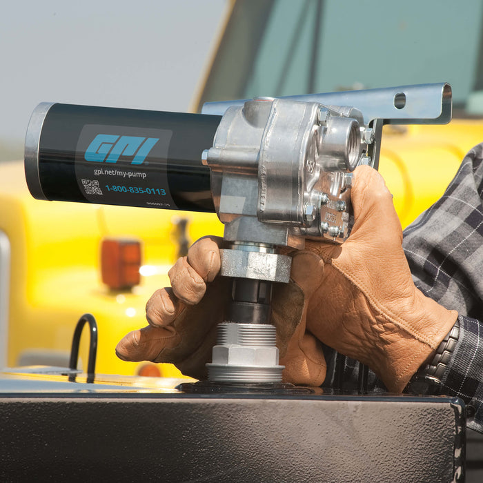 GPI M-150 Pump (ABGAS / JET A Compatible) being stalled on a black fuel tank by a person wearing leather work gloves