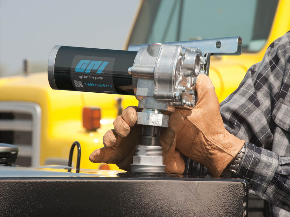 GPI M-150 Pump (ABGAS / JET A Compatible) being stalled on a black fuel tank by a person wearing leather work gloves