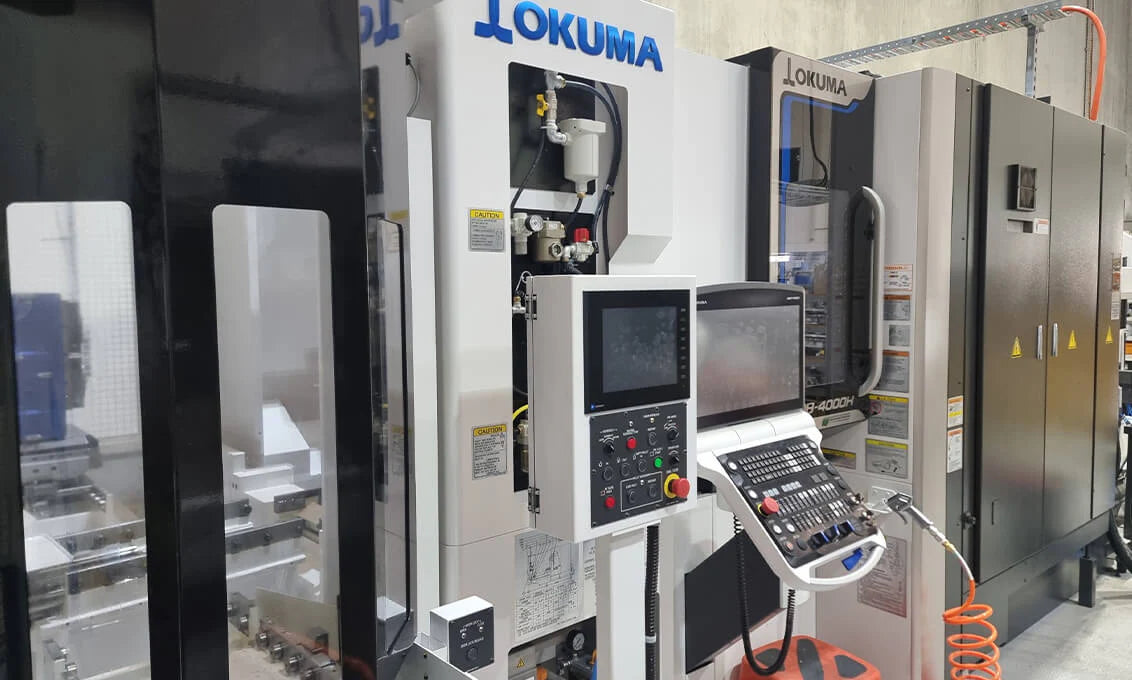 CNC machine with 'Tokuma' branding in a workshop setting
