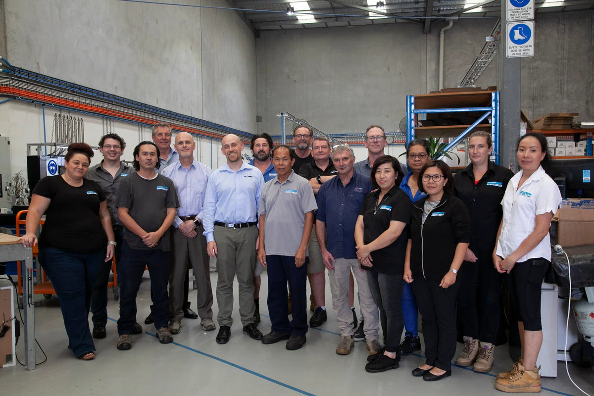 Group of people posing for a photo in a warehouse setting