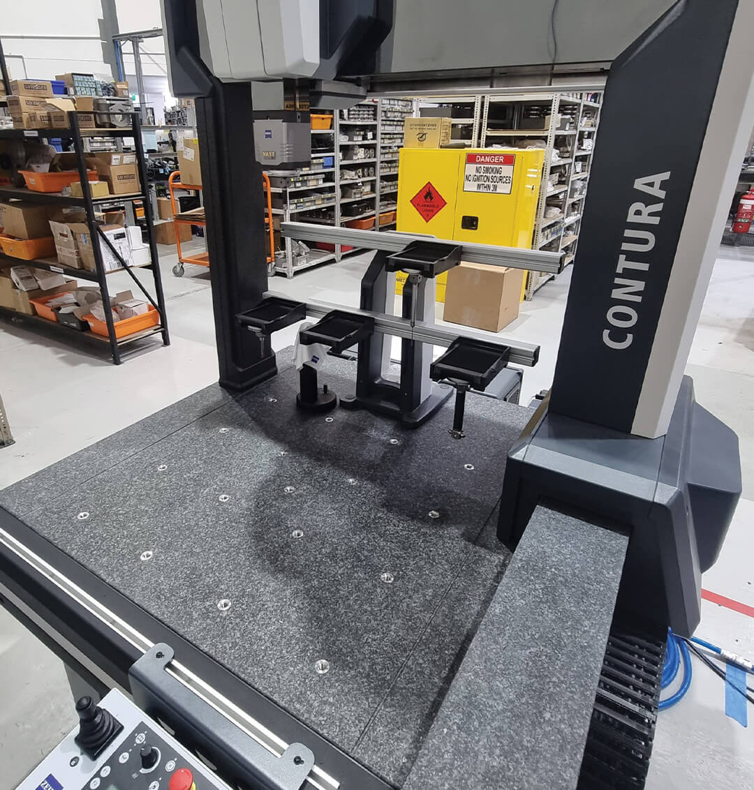Industrial machine with 'Contura' branding in a warehouse setting