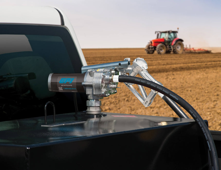 GPI M-150 with manual shut-off unleaded nozzle mounted to a black tank in a pickup in front of a tractor on a field