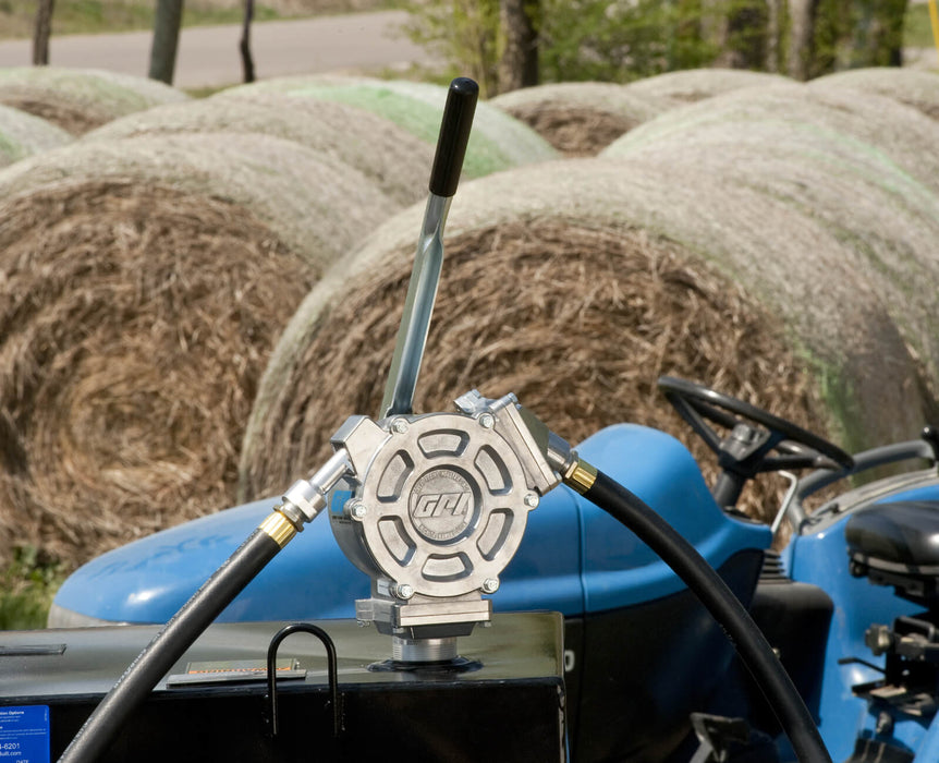 GPI HP-100-UL fluid transfer hand pump mounted to tank in front of a tractor and round bales