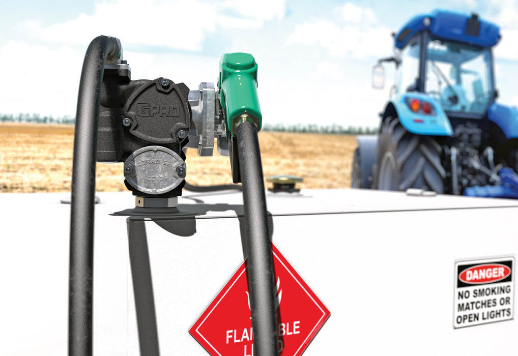GPRO V25 fuel transfer pump with automatic nozzle on a fuel tank by a blue tractor on a grain field